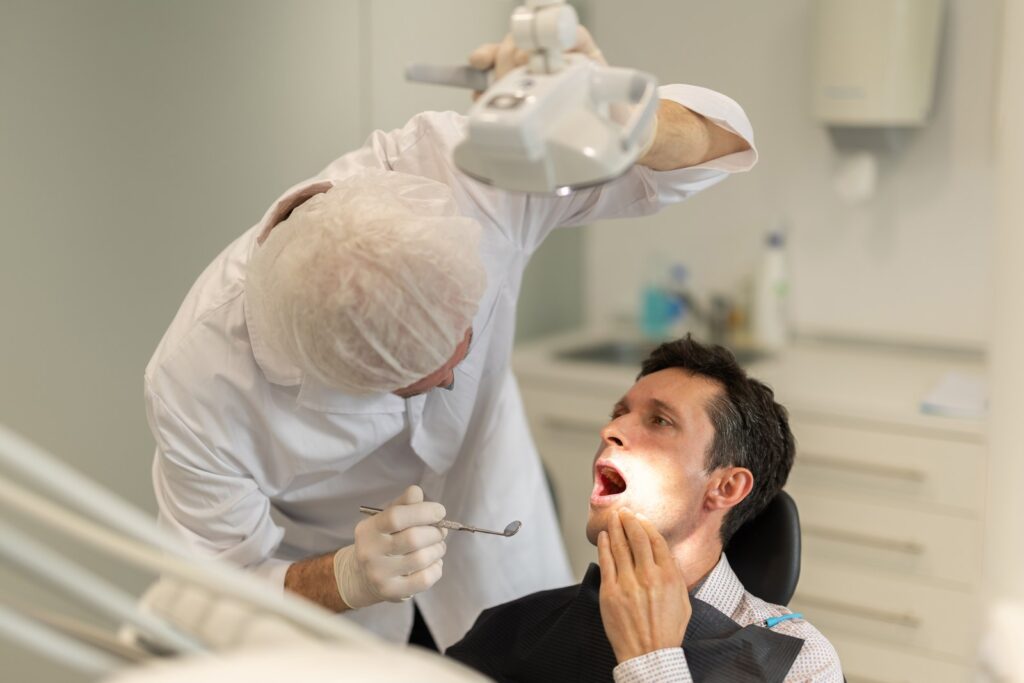 Dentist examining a patient's teeth during an emergency dental visit